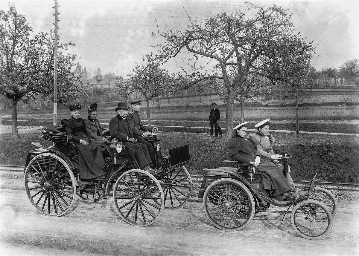 Benz Motor-Velociped („Velo“) mit 1,5-PS-Motor (rechts, Produktionszeitraum 1894 bis 1898) und Benz Patent-Motorwagen „Phaeton“ (links). Foto einer Ausfahrt im Jahr 1895 von Weinheim nach Schriesheim entlang der Bergstraße. Im Velo: Clara (am Lenkrad) und
